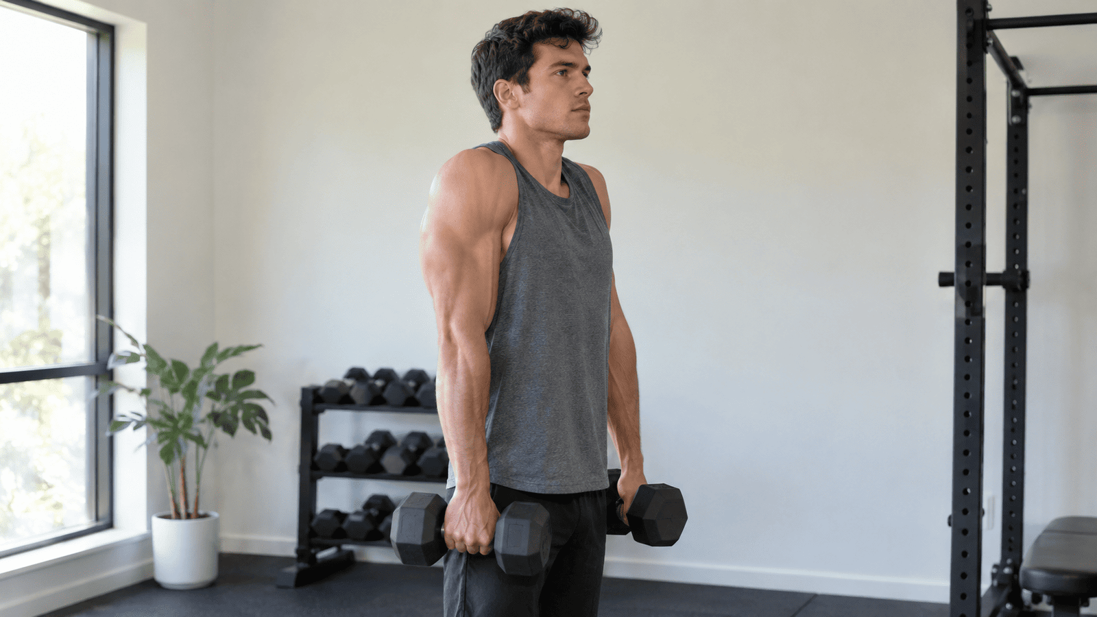 Man doing dumbbell shrugs at home to train his upper traps